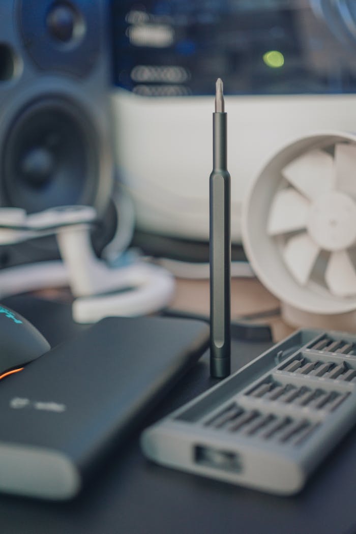 Close-up of a magnetic screwdriver set on a cluttered desk setup.